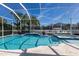 Stunning screened-in pool and spa featuring a mosaic tile design and a spacious travertine deck for relaxation at 581 Mast Dr, Bradenton, FL 34208