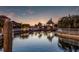 View of boat dock and gazebo on the water at sunset, showcasing a peaceful waterfront lifestyle at 581 Mast Dr, Bradenton, FL 34208
