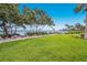 Lush green lawn extends to the waterfront with mature trees and landscaping at 600 Manatee Ave # 114, Holmes Beach, FL 34217