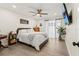 Bright bedroom with ceiling fan, TV, and curtains allowing natural light at 600 Manatee Ave # 114, Holmes Beach, FL 34217