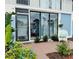 Inviting front entrance featuring tiled patio, sliding glass doors, and a cozy wicker chair surrounded by lush landscaping at 600 Manatee Ave # 114, Holmes Beach, FL 34217