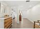Bright hallway with wood floors connecting to a bedroom and the front door at 600 Manatee Ave # 114, Holmes Beach, FL 34217