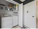 A compact laundry room with a washer, dryer, water heater, and shelving for storage at 600 Manatee Ave # 114, Holmes Beach, FL 34217