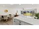 Bright open concept living and dining area with sliding glass doors and white quartz countertops at 600 Manatee Ave # 114, Holmes Beach, FL 34217