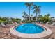 Beautiful community pool with palm trees, lounge chairs, and manicured landscaping at 600 Manatee Ave # 114, Holmes Beach, FL 34217