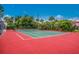Outdoor tennis court surrounded by lush trees and landscaping, perfect for active recreation and enjoying the beautiful weather at 600 Manatee Ave # 114, Holmes Beach, FL 34217