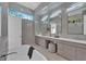 Bright bathroom features double sink vanity, soaking tub, walk-in shower and window that brings in natural light at 603 Tremont St, Sarasota, FL 34242