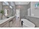 Bright bathroom features double sink vanity, soaking tub, walk-in shower and window that brings in natural light at 603 Tremont St, Sarasota, FL 34242