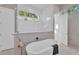 Modern bathroom features a soaking tub, white tile shower, and a bright window at 603 Tremont St, Sarasota, FL 34242