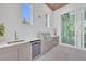 Outdoor kitchen includes a stainless steel grill, sink, under-counter refrigerator, and white countertops at 603 Tremont St, Sarasota, FL 34242