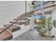 Staircase with wood treads and black railings, illuminated by a large window with green chair to the side at 603 Tremont St, Sarasota, FL 34242