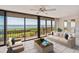 Enjoy amazing views of the water in this bright living room with floor to ceiling windows and tile flooring at 6430 Sun Eagle Ln # 103, Bradenton, FL 34210