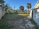 Spacious backyard featuring a combination of grass, gravel, and greenery at 704 Chippy Ln, Nokomis, FL 34275