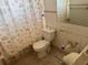 Compact bathroom with a toilet and a shower featuring a decorative shower curtain at 704 Chippy Ln, Nokomis, FL 34275