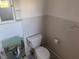 This bathroom features a toilet, sink, and tiled walls at 704 Chippy Ln, Nokomis, FL 34275