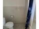 Simple bathroom setup with a toilet, tiled walls, and essential fixtures, space for improvements at 704 Chippy Ln, Nokomis, FL 34275