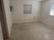 Empty bedroom with minimal furnishings and a window, ready for customization at 704 Chippy Ln, Nokomis, FL 34275