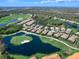 Scenic aerial view of homes nestled along a golf course with lush landscaping and water features at 7052 Woodmore Ter, Lakewood Ranch, FL 34202