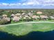 Aerial view of home situated by a lake with a screened lanai, lush landscaping, and beautiful neighborhood at 7052 Woodmore Ter, Lakewood Ranch, FL 34202