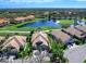 Elevated view of a single-story home surrounded by lush greenery, a golf course, and serene pond at 7052 Woodmore Ter, Lakewood Ranch, FL 34202