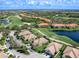 Aerial view of residences by a golf course and pond, showcasing the community's layout and landscaping at 7052 Woodmore Ter, Lakewood Ranch, FL 34202