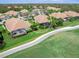 Aerial view of home and neighborhood with screened lanai, golf course access, and lush green surroundings at 7052 Woodmore Ter, Lakewood Ranch, FL 34202