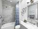 Bright bathroom with tub, shower, vanity with a gray cabinet and framed mirror at 7052 Woodmore Ter, Lakewood Ranch, FL 34202