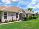 Inviting single-story home with a well-manicured lawn, mature landscaping, and a welcoming entryway at 7052 Woodmore Ter, Lakewood Ranch, FL 34202