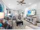 Bright living room with large screen TV, ceiling fan, area rug and comfortable seating at 7052 Woodmore Ter, Lakewood Ranch, FL 34202