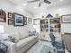 Comfortable home office with built-in bookshelves, soft sofa, decorative rug and wood-paneled walls at 7052 Woodmore Ter, Lakewood Ranch, FL 34202
