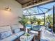 Relaxing screened patio with plush seating, coffee table, and views of the lush backyard landscaping and pool at 7052 Woodmore Ter, Lakewood Ranch, FL 34202