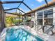 Beautiful in-ground pool featuring a screened-in lanai, patio seating, and well-maintained landscaping at 7052 Woodmore Ter, Lakewood Ranch, FL 34202