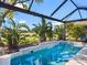 Sparkling pool surrounded by lush tropical plants and landscaping inside screened lanai at 7052 Woodmore Ter, Lakewood Ranch, FL 34202