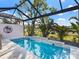 Inviting backyard pool with tiled accents, tropical landscaping, and a screened enclosure at 7052 Woodmore Ter, Lakewood Ranch, FL 34202