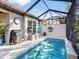 Backyard pool with grill, outdoor seating, lush plants, and screened lanai for outdoor enjoyment at 7052 Woodmore Ter, Lakewood Ranch, FL 34202