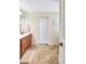 The light and bright bathroom includes a double sink vanity with wood cabinets and tile flooring at 7214 35Th E Ln, Sarasota, FL 34243