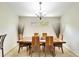 Formal dining room featuring a modern chandelier, contemporary decor and tan carpeting at 7214 35Th E Ln, Sarasota, FL 34243