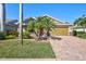 Charming home with a brick driveway, mature palm trees and a two-car garage adding to the curb appeal at 7214 35Th E Ln, Sarasota, FL 34243