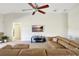 Comfortable living room featuring a ceiling fan and a large leather sectional couch at 7214 35Th E Ln, Sarasota, FL 34243