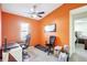 Well-lit home office with orange walls, a treadmill, and functional desk space at 7214 35Th E Ln, Sarasota, FL 34243