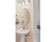 Half bathroom with pedestal sink, decorative mirror, and updated lighting at 7887 Limestone Ln # 12-102, Sarasota, FL 34233