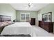 Relaxing bedroom with a ceiling fan, large window, and dark wood furniture at 7887 Limestone Ln # 12-102, Sarasota, FL 34233