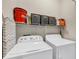Laundry room with washer, dryer, storage shelf, and ironing board at 7887 Limestone Ln # 12-102, Sarasota, FL 34233