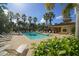 Community pool area surrounded by palm trees and lounge chairs at 7887 Limestone Ln # 12-102, Sarasota, FL 34233