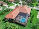 Aerial view of a luxurious home featuring a screened-in pool and well-manicured landscaping at 7934 Royal Birkdale Cir, Lakewood Ranch, FL 34202