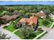 Aerial view of a luxurious home in a beautifully landscaped neighborhood near a lake at 7934 Royal Birkdale Cir, Lakewood Ranch, FL 34202