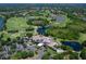 Aerial view of a lush golf course community, lakes, and grand clubhouse with parking at 7934 Royal Birkdale Cir, Lakewood Ranch, FL 34202