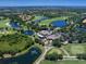 Gorgeous aerial view of golf course community, lakes, and clubhouse with ample parking at 7934 Royal Birkdale Cir, Lakewood Ranch, FL 34202