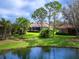 Scenic backyard featuring a serene lake view and manicured lawn with mature landscaping at 7934 Royal Birkdale Cir, Lakewood Ranch, FL 34202