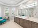 Well-lit bathroom features double vanity, large mirror, and shuttered windows for natural light at 7934 Royal Birkdale Cir, Lakewood Ranch, FL 34202